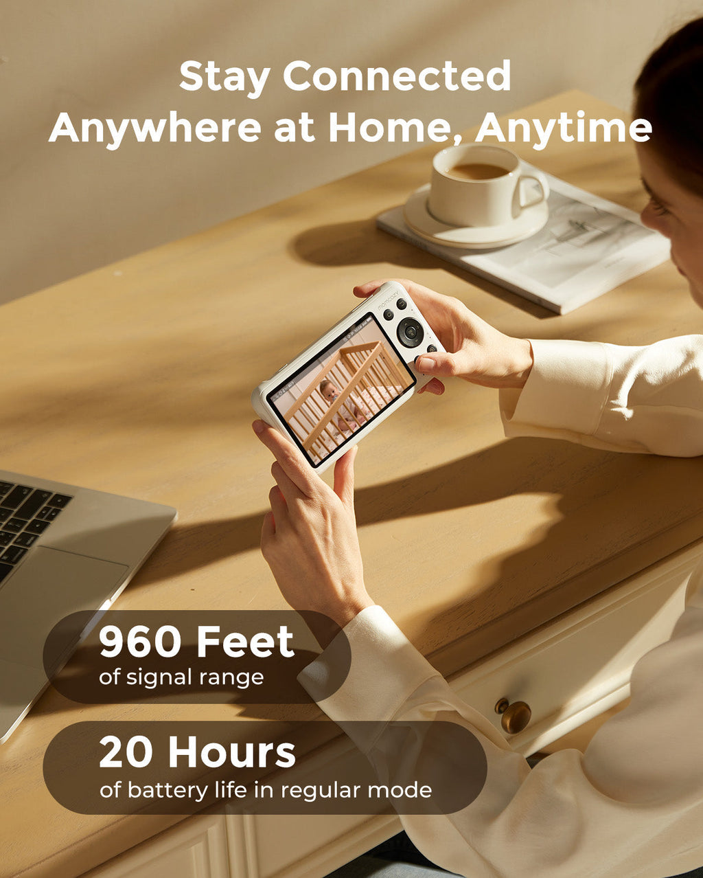 Woman holding a 1080p full HD camera baby monitor, showing a crib, with 960 ft signal and 20-hour battery life.