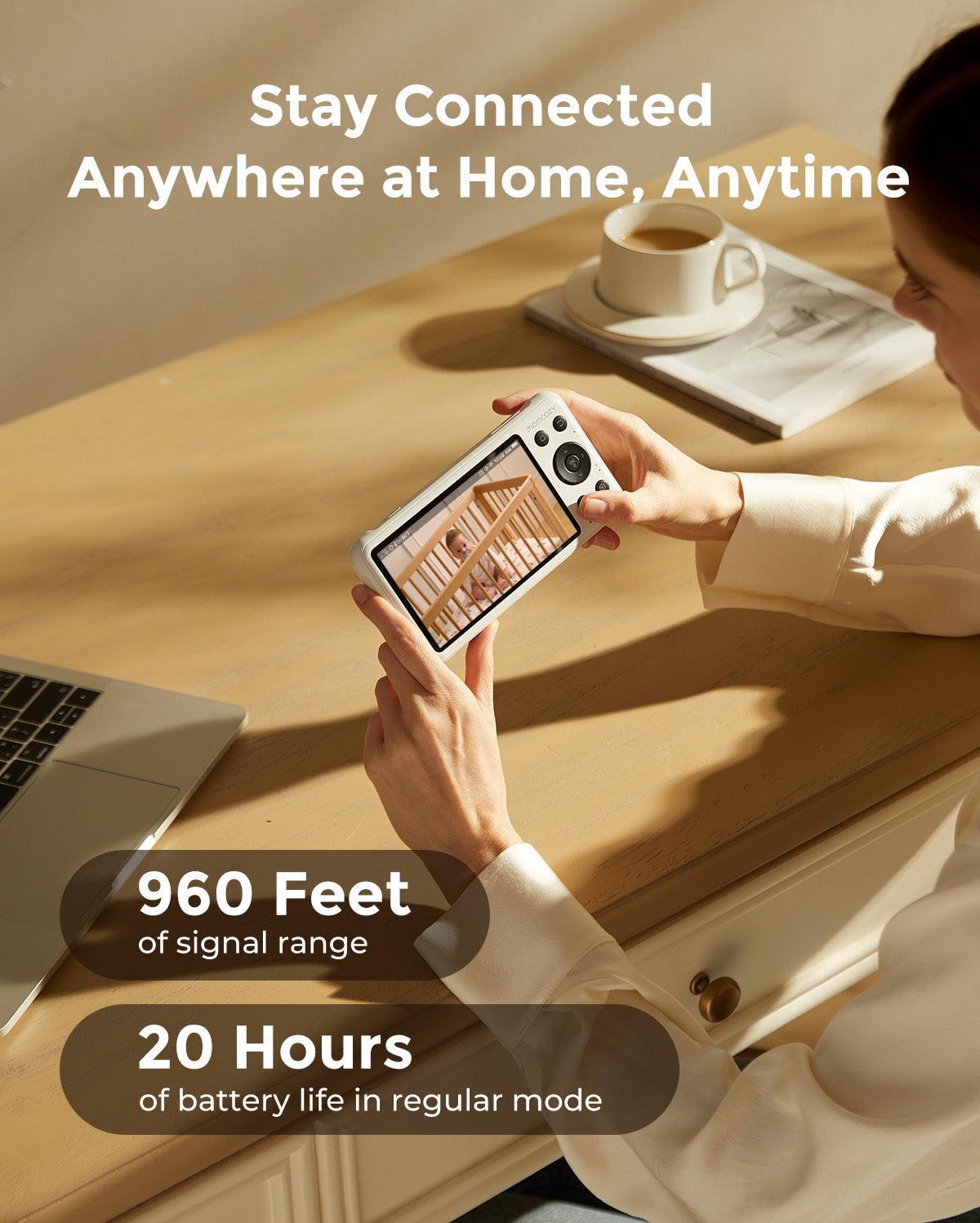 Woman holding a 1080p full HD camera baby monitor, showing a crib, with 960 ft signal and 20-hour battery life.