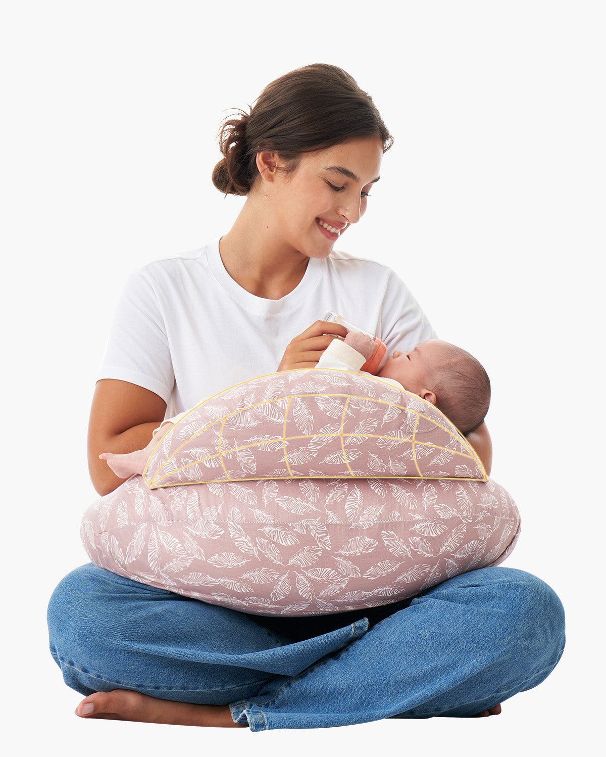 Mother uses multifunctional adjustable pink nursing pillow with feather pattern to feed baby.