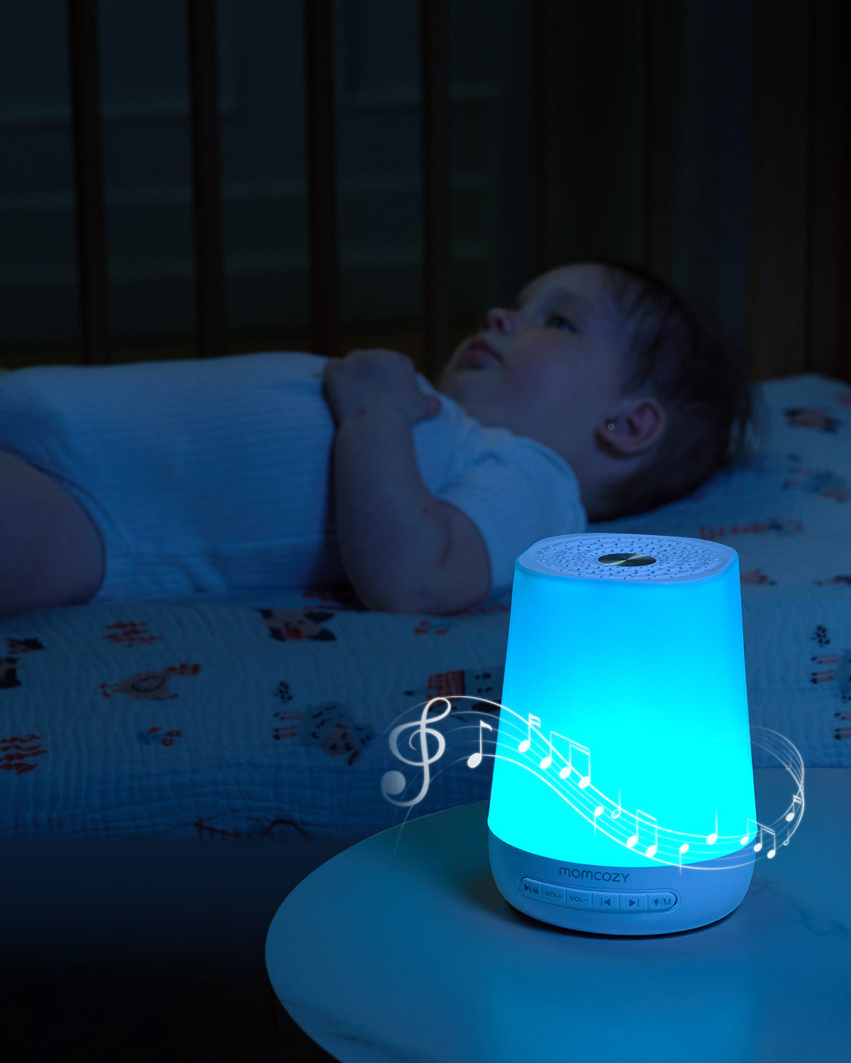 Smart Baby Sound Machine with MOMCOZY logo, emitting blue light and musical notes. App remote control features.