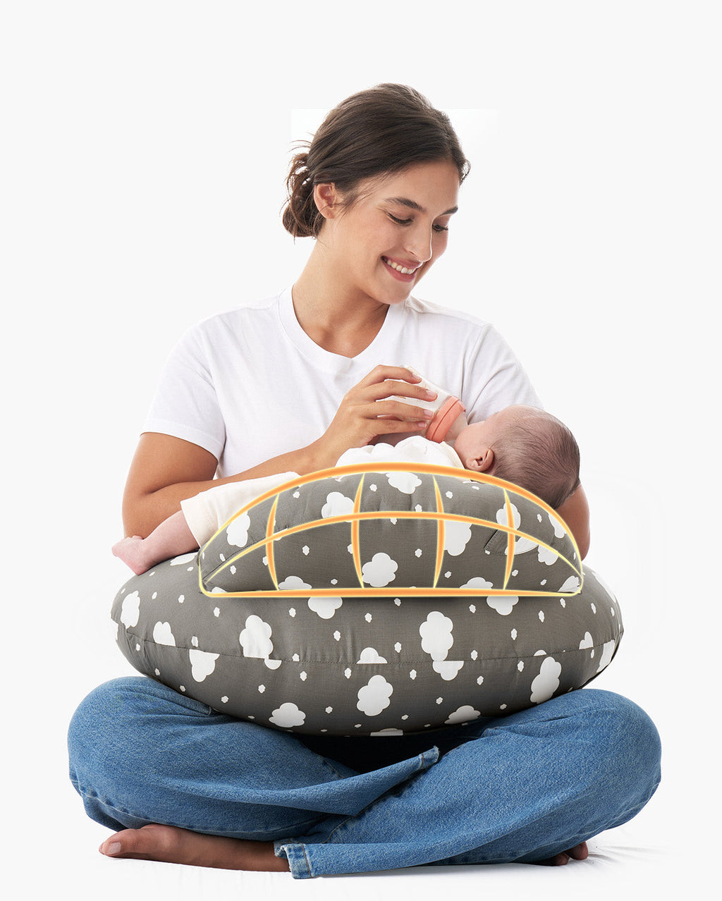 Woman bottle-feeding baby on multifunctional adjustable nursing pillow with cloud pattern.