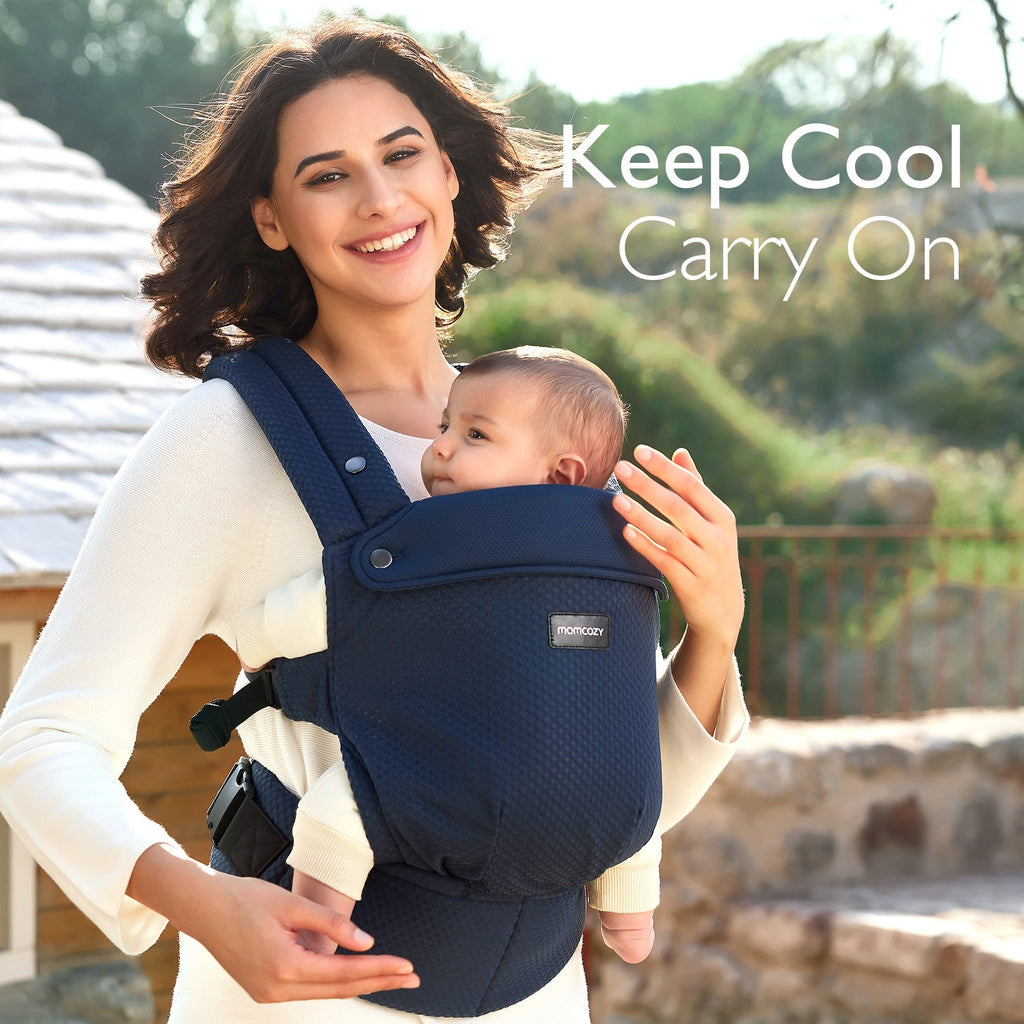 Momcozy PureHug baby carrier, navy blue, with breathable mesh. Mother holding baby, comfortable design.