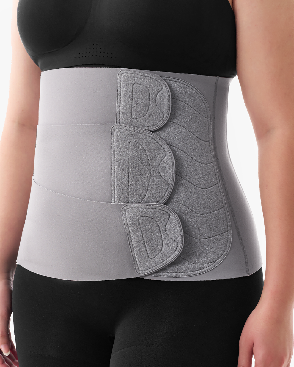 Momcozy Ergowrap Postpartum Belly Band in light gray, worn by a woman, showing adjustable straps for postpartum support.