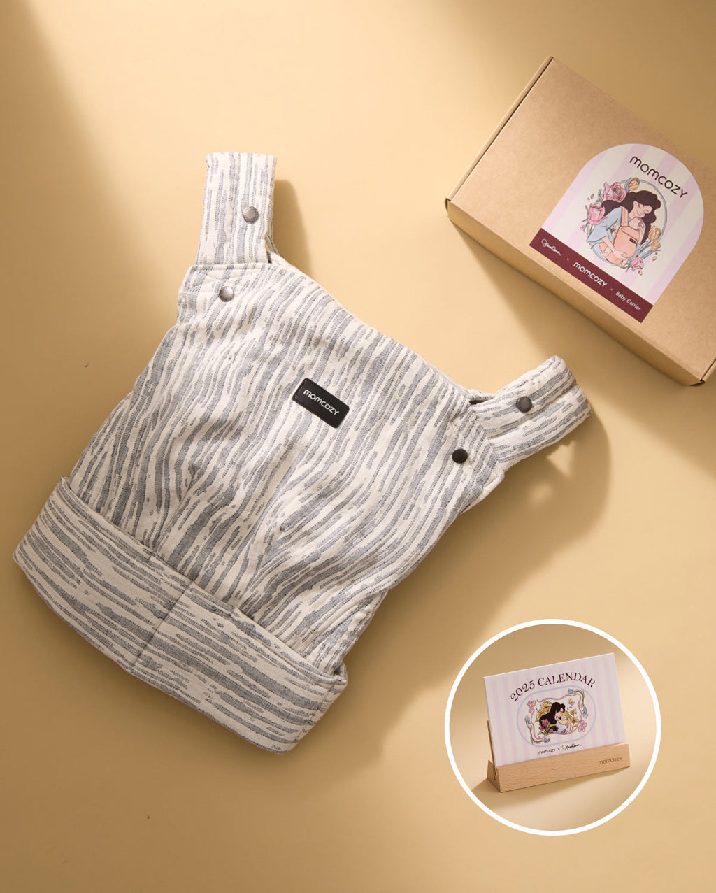 Momcozy PureHug Baby Carrier in striped grey and white design, with Momcozy branding and 2025 calendar.